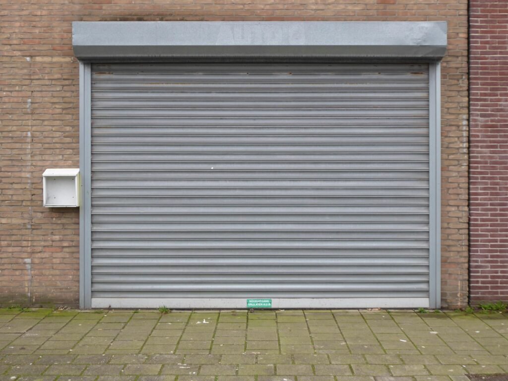 Commercial garage door Closed grey metal roller shutter commercial garage door for security and protection in urban exterior.